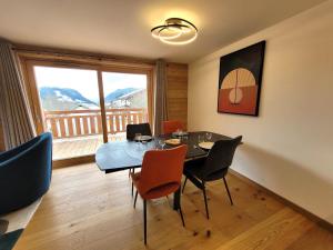 a dining room with a table and chairs and a window at Appartement lumineux 3* avec terrasse, 2 chambres, proche centre et pistes, garage inclus - FR-1-598-163 in Les Gets +6 photos