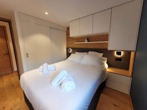 a bedroom with a large white bed with white pillows at Appartement lumineux 3* avec terrasse, 2 chambres, proche centre et pistes, garage inclus - FR-1-598-163 in Les Gets