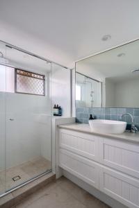 W łazience znajduje się umywalka i przeszklony prysznic. w obiekcie Absolute Beachfront Bliss on Kings Beach w mieście Caloundra