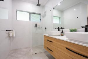 y baño blanco con lavabo y ducha. en Hamptons Spa Villa - Luxury 3 bedroom 2 bathroom home with outdoor Hot tub, en Edge Hill