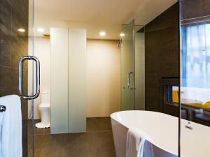 a bathroom with a bath tub and a toilet at Stay with Bintang in Kuala Lumpur