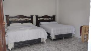 two beds sitting next to each other in a room at Alojamiento San Juan in San Juan La Laguna