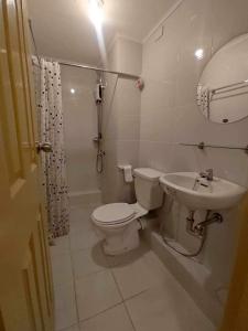 a bathroom with a toilet and a sink at One Spatial Condo in Iloilo City