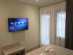 a hotel room with a television on the wall at MENTA in Litochoro