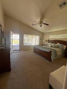 um quarto com uma cama e uma ventoinha de tecto em Sunset Oasis em Fort Mohave