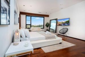 a bedroom with a large white bed and windows at Spectacular Views: Exquisite Villa, Pool, Jacuzzi! in Los Angeles