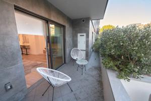 - un balcon avec 2 chaises et des tables dans un bâtiment dans l'établissement Hidden Gem in LA: Stylish Haven, à Los Angeles