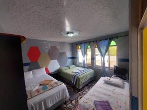 a room with two beds and a tv in it at Alojamiento San Juan in San Juan La Laguna
