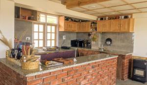 a kitchen with wooden cabinets and a brick counter top at Dyar Koul in Shimla