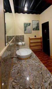 a bathroom with a marble counter top with a sink at TAGBALAYON Lodging House in Siquijor