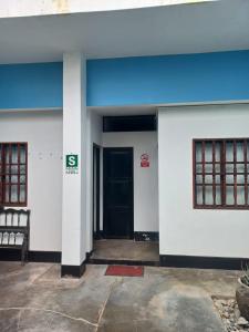 une porte d'entrée d'un bâtiment avec une porte noire dans l'établissement El Boquerón - Hospedaje, à Huanchaco