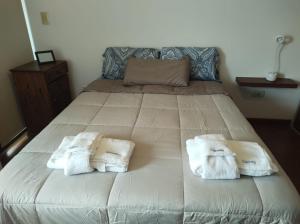 a bedroom with a bed with towels on it at Departamento Centrico con terraza propia in Río Cuarto