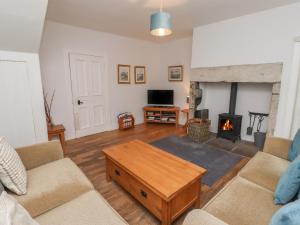 a living room with a couch and a fireplace at Avocet Cottage in Bamburgh