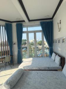 sypialnia z dużym łóżkiem z niebieskimi zasłonami w obiekcie KimMy Home w mieście Phan Thiet