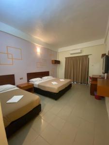 a hotel room with two beds and a desk at Pangkor Bay View Beach Resort in Pangkor