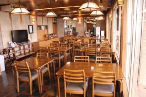 eine Reihe von Tischen und Stühlen in einem Restaurant in der Unterkunft Hotel Shiosai in Fujisawa