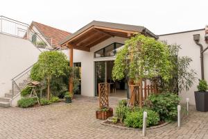 a house with a courtyard with trees and plants at Weingut Familie Bauer in Großriedenthal