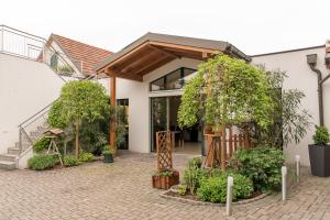 ein Haus mit einem Innenhof mit Bäumen und Pflanzen in der Unterkunft Weingut Familie Bauer in Großriedenthal