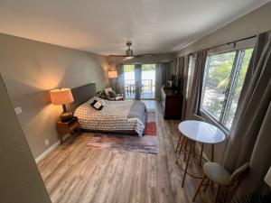 1 dormitorio con 1 cama, mesa y sillas en UNIT C - Sandy Toes Getaway in Kona, en Kailua-Kona