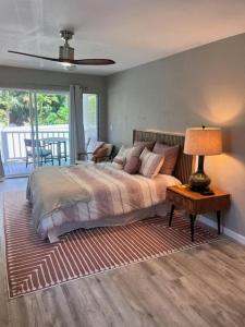 1 dormitorio con 1 cama y 1 mesa con lámpara en UNIT C - Sandy Toes Getaway in Kona, en Kailua-Kona