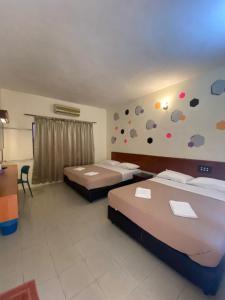Habitación de hotel con 2 camas y escritorio en Pangkor Bay View Beach Resort en Pangkor