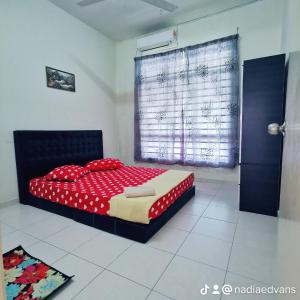馬六甲的住宿－HOMESTAY MURAH MELAKA Melayu Sahaja，一间卧室配有一张带红色床单的床和一扇窗户。
