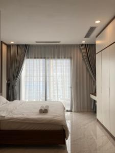 a bedroom with a bed with two wedding shoes on it at Luxury econest - Apartment with swimming pool & gym in Hanoi