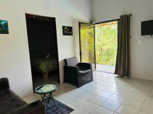 uma sala de estar com um sofá e uma cadeira em Jonka House Private Jungle Oasis em Chachagua