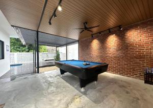 a pool table in a room with a brick wall at The Luxurious 27, Johor Bahru in Johor Bahru