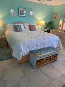 1 dormitorio con 1 cama con edredón blanco en Estero Beach and Tennis PH5 Building C condo, en Fort Myers Beach