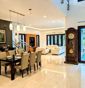 uma sala de estar com uma mesa de jantar e um relógio avô em Cottonwood Villa Mewah Nilaya @Dago - BBQ Pingpong em Bandung