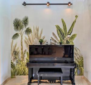 a black piano in a room with plants at Cottonwood Villa Mewah Nilaya @Dago - BBQ Pingpong in Bandung