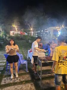 a man and a woman eating food at a party at Tran Chau Garden Home in Cat Ba