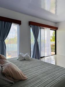 - une chambre avec un grand lit et 2 fenêtres dans l'établissement Bella's Country Room, à Tanque