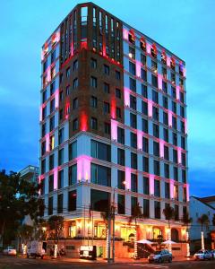 a tall building with pink lights on it at Danaciti Hotel in Danang