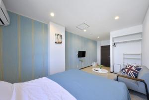 a bedroom with blue walls and a bed and a tv at seaside villa HILIFE - Vacation STAY 99018 in Kogushi