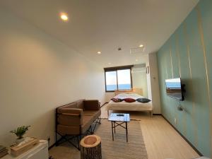 a bedroom with a bed and a couch and a chair at seaside villa HILIFE - Vacation STAY 99018 in Kogushi