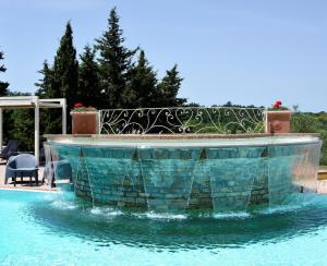 een zwembad met een fontein in het midden van een tuin bij Ferienhaus für 10 Personen und 4 Kinder in Chianni, Toskana Provinz Pisa in Rivalto