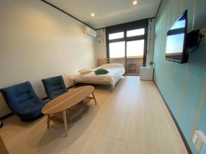 a room with a bed and a table and chairs at seaside villa HILIFE - Vacation STAY 99007 in Kogushi