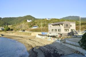 - un bâtiment à côté d'une plage donnant sur l'océan dans l'établissement seaside villa HILIFE - Vacation STAY 99007, à Kogushi