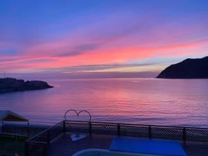 una terraza con vistas al océano al atardecer en seaside villa HILIFE - Vacation STAY 51318v en Shimonoseki