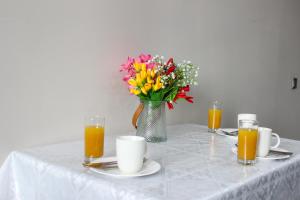 uma mesa com um vaso de flores e sumo de laranja em - Представляем вам современную! Комфортную, стильными Дизайном, в новом элитным Жилом Комплексе уютную квартиру. em Oktryabr'