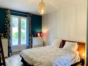 a bedroom with a bed and a large window at Charming, quiet house 7 minutes walk from center in Antibes