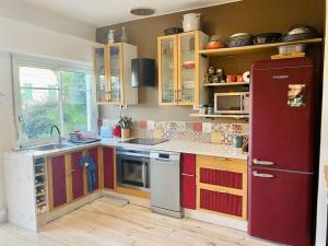 a kitchen with a red refrigerator and wooden cabinets at Charming, quiet house 7 minutes walk from center in Antibes