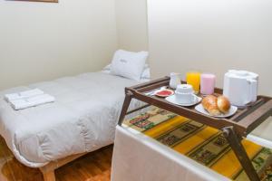 a room with a bed with a tray of food at Killa Sumak in Machu Picchu