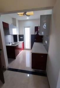 a kitchen with red and white cabinets and a sink at Baidwan’z 120/c in Zirakpur