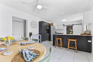Un comedor y una cocina con mesa y sillas. en Eden Lodge, en Woorim