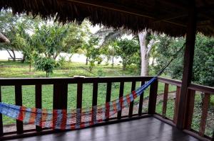a hammock on the porch of a resort at River Point Hostel in Puerto Maldonado