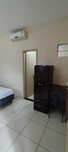 a room with a bedroom with a desk and a bed at POUSADA ACONCHEGO HOTEL in Imperatriz