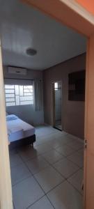 pusty pokój z łóżkiem i oknem w obiekcie POUSADA ACONCHEGO HOTEL w mieście Imperatriz